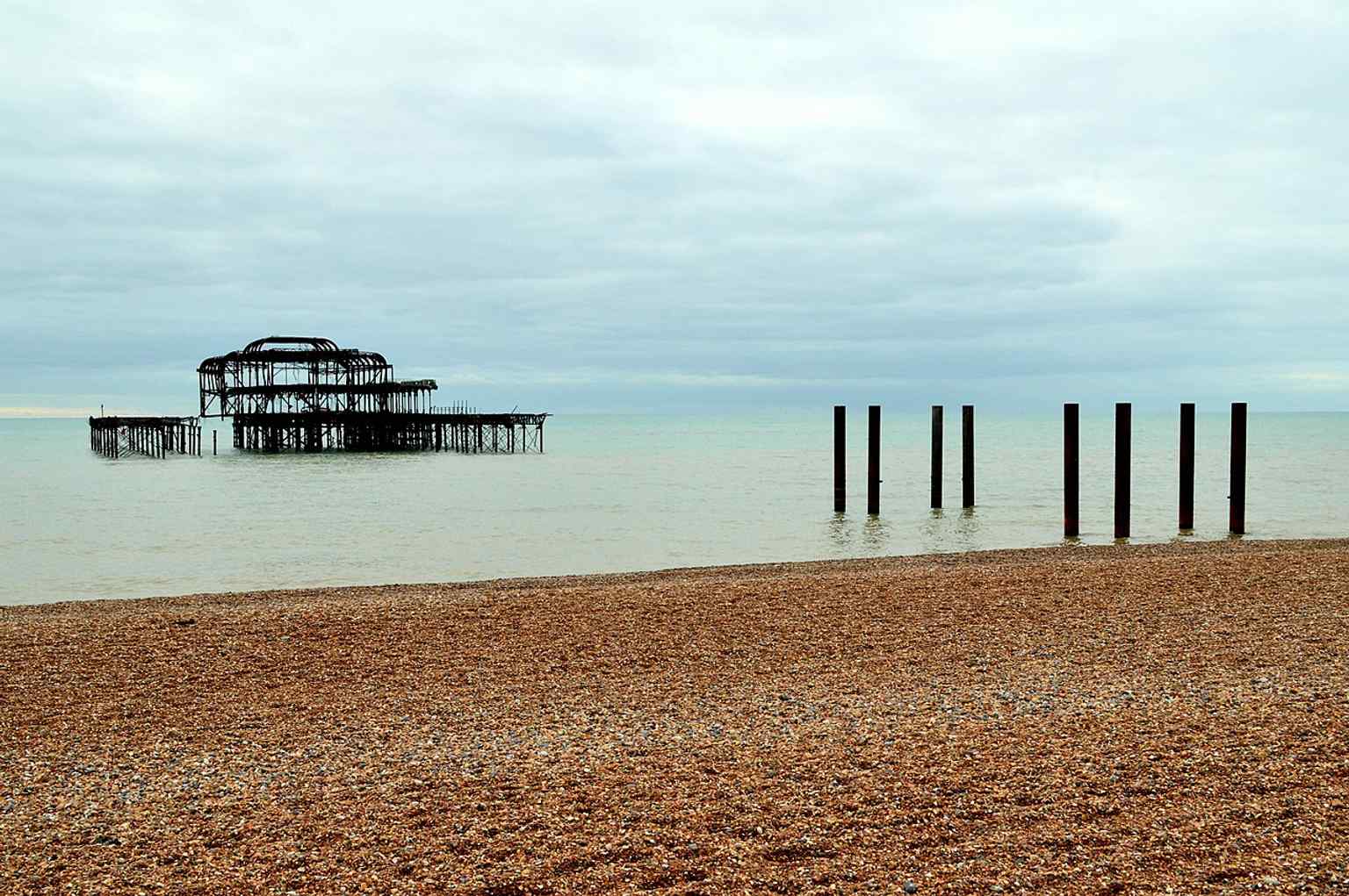 A wide view of the derelict West Pier skeleton, showing how storms and collapse turned it into an icon of Brighton’s seafront.