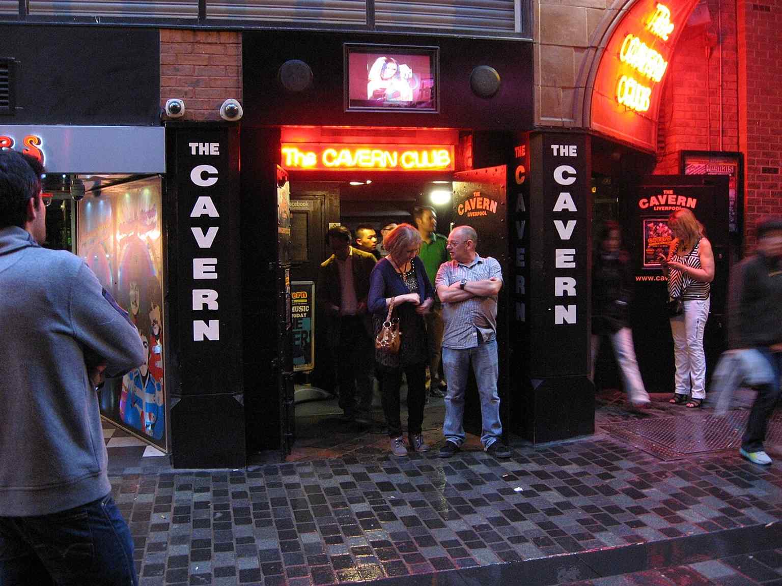 The Cavern Club exterior with its iconic brick arch and signage, evoking the underground venue where the Beatles played hundreds of times.