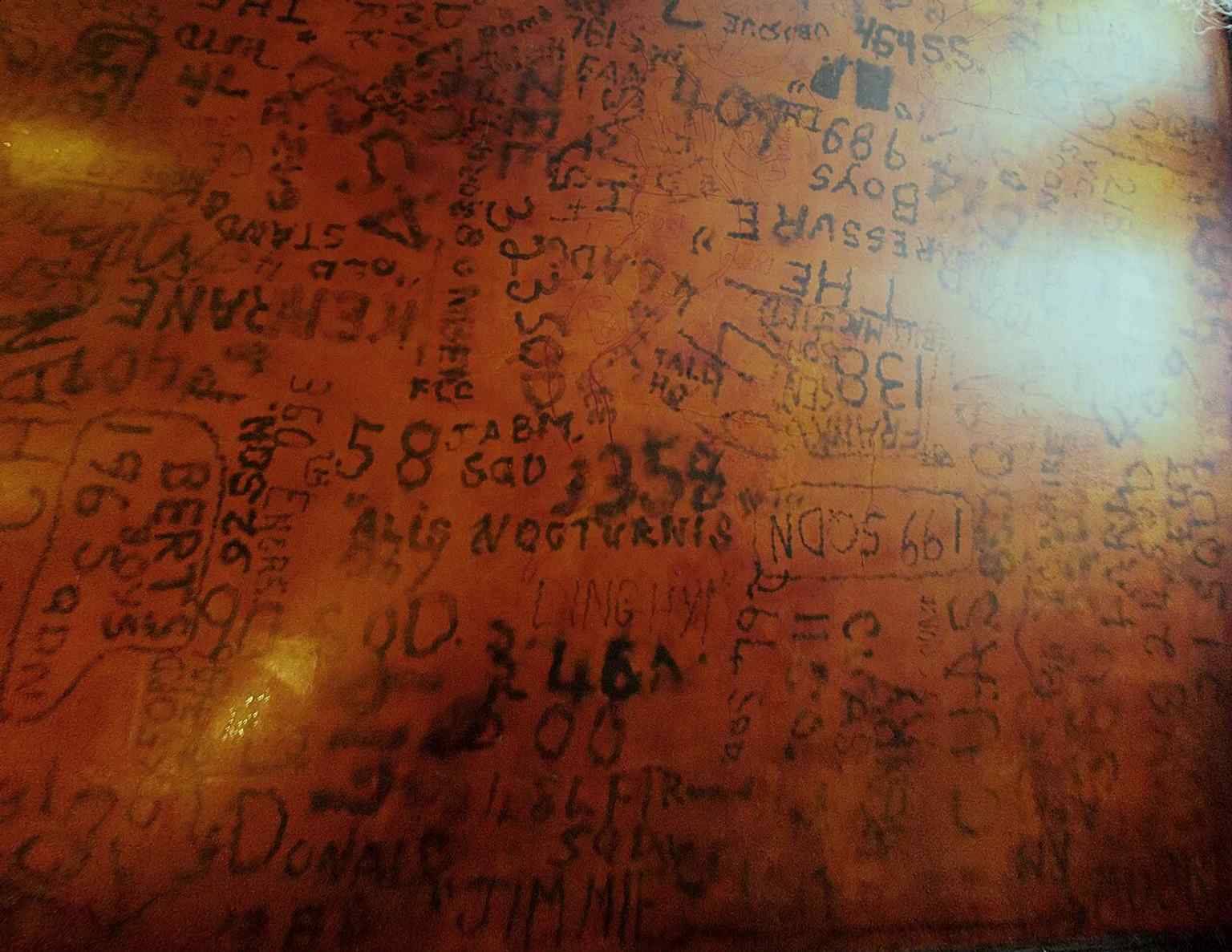 Another view of the RAF Bar ceiling, showing the preserved signatures and squadron markings burned into the plaster.