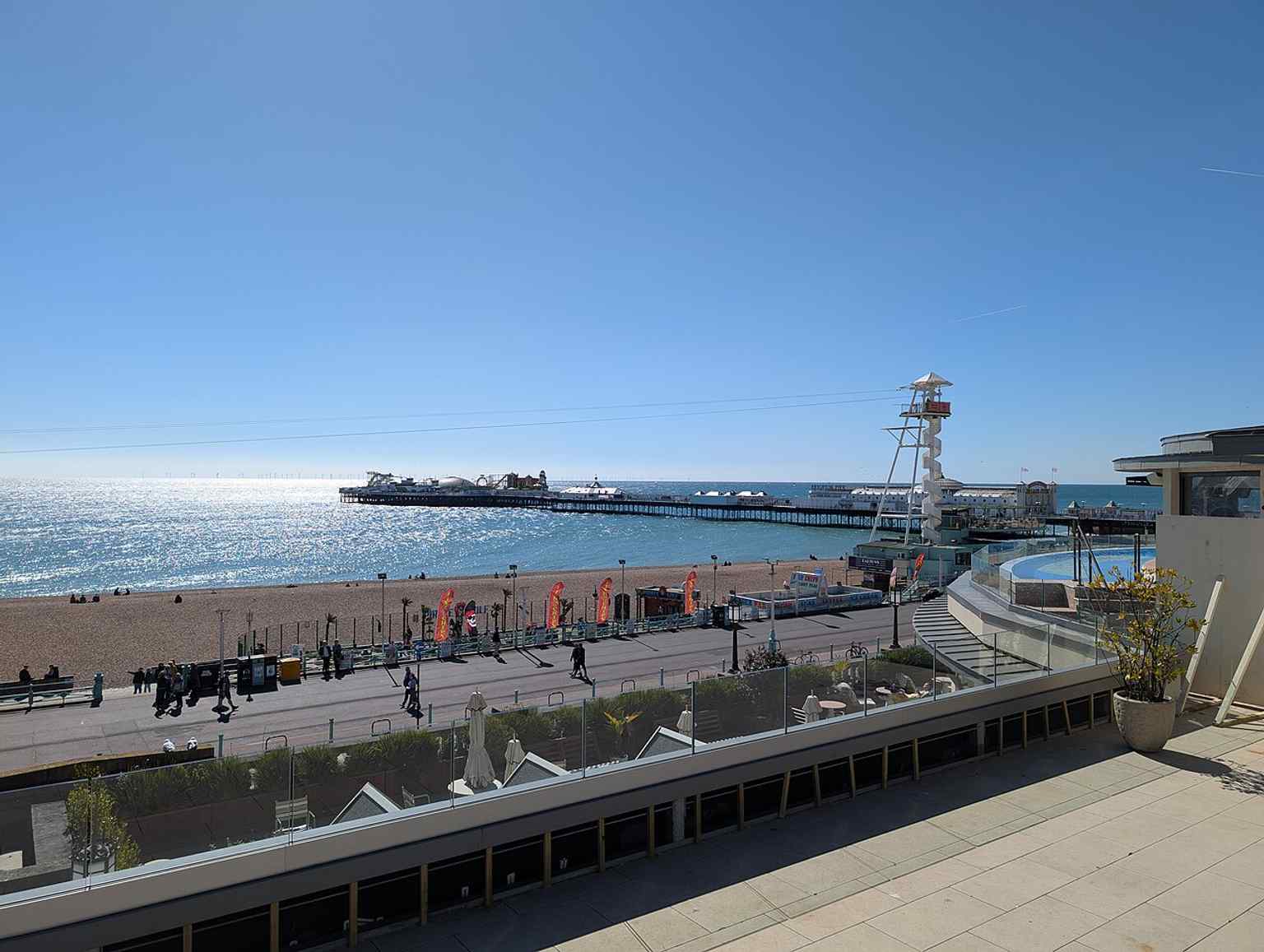 A sweeping modern view from Madeira Drive showing the pier stretching into the sea, matching its role as Brighton’s most famous seafront landmark.