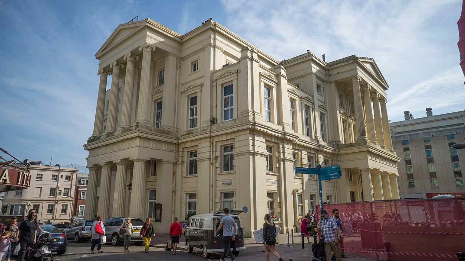 A clear modern view of the town hall from the street, tying the 19th-century landmark to Brighton’s busy city centre today.