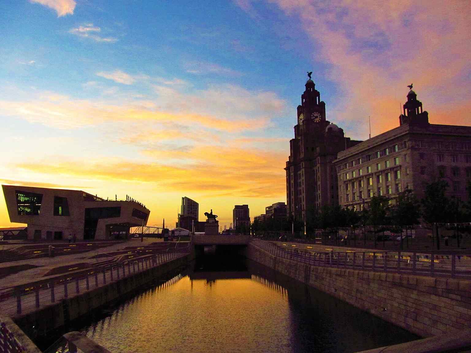 The building beside its waterfront neighbours, showing the Royal Liver Building as part of Liverpool’s famous Three Graces and World Heritage dockland.