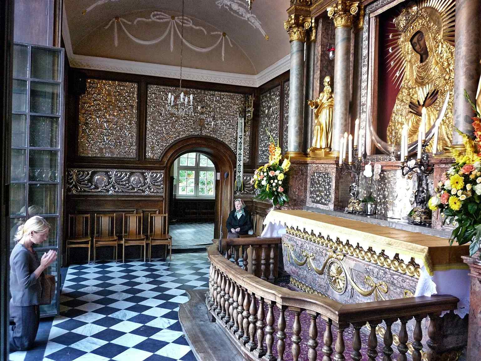 Prayer inside the chapel, echoing the long tradition of Masses and multilingual devotion at the shrine.