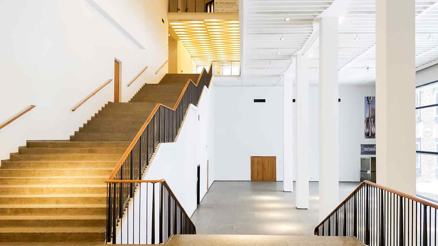 The grand entrance hall of the museum, featuring a straight staircase with three landings that leads to the main exhibition floors.