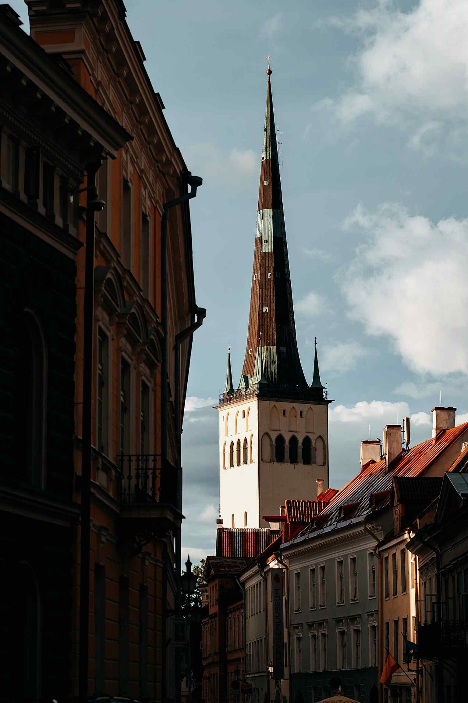 At sunset, the tower glows above the historic rooftops, echoing the church’s long role as a city beacon.