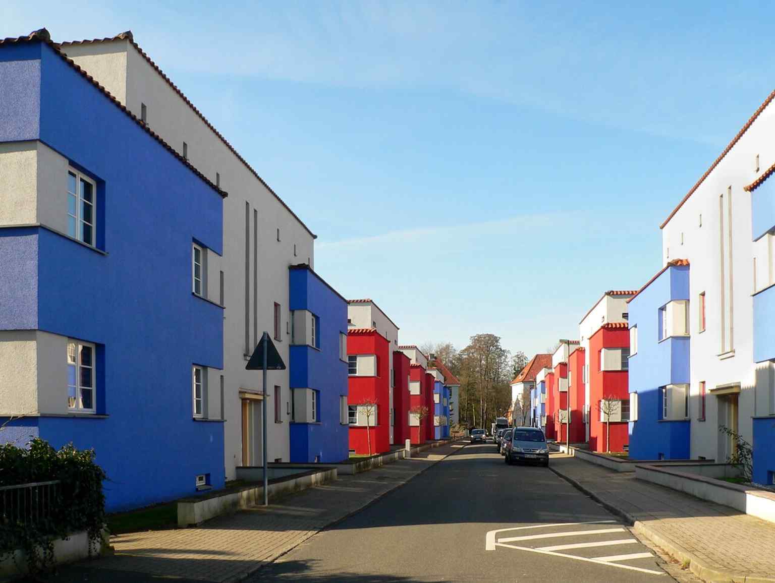This street view captures the symmetrical arrangement of the eight flat-roofed four-family houses, each with its own front and utility garden, lining the newly created Italienischer Garten street.