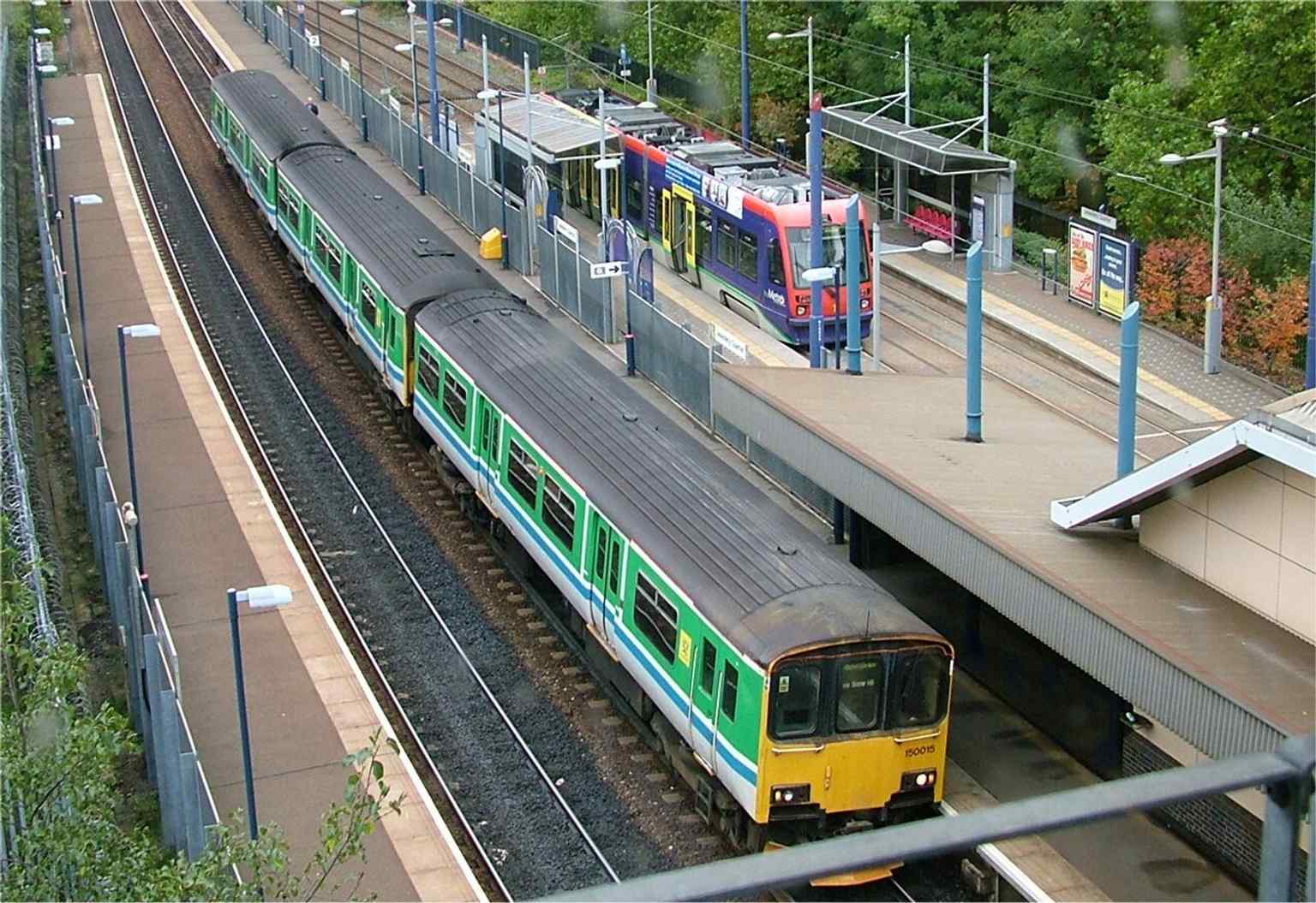 A rare rail-and-tram interchange in one view: Jewellery Quarter station with a train and a tram side by side, reflecting the 1999 addition of Midland Metro services.