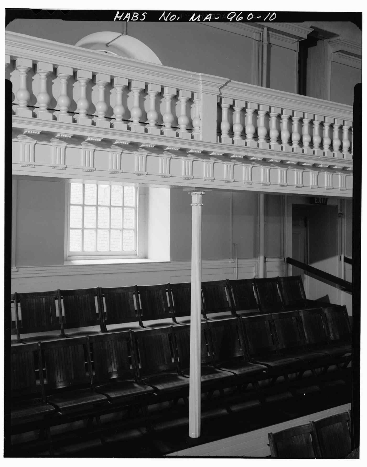 A cast-iron support and gallery balustrade detail, revealing later preservation work inside the historic sanctuary.