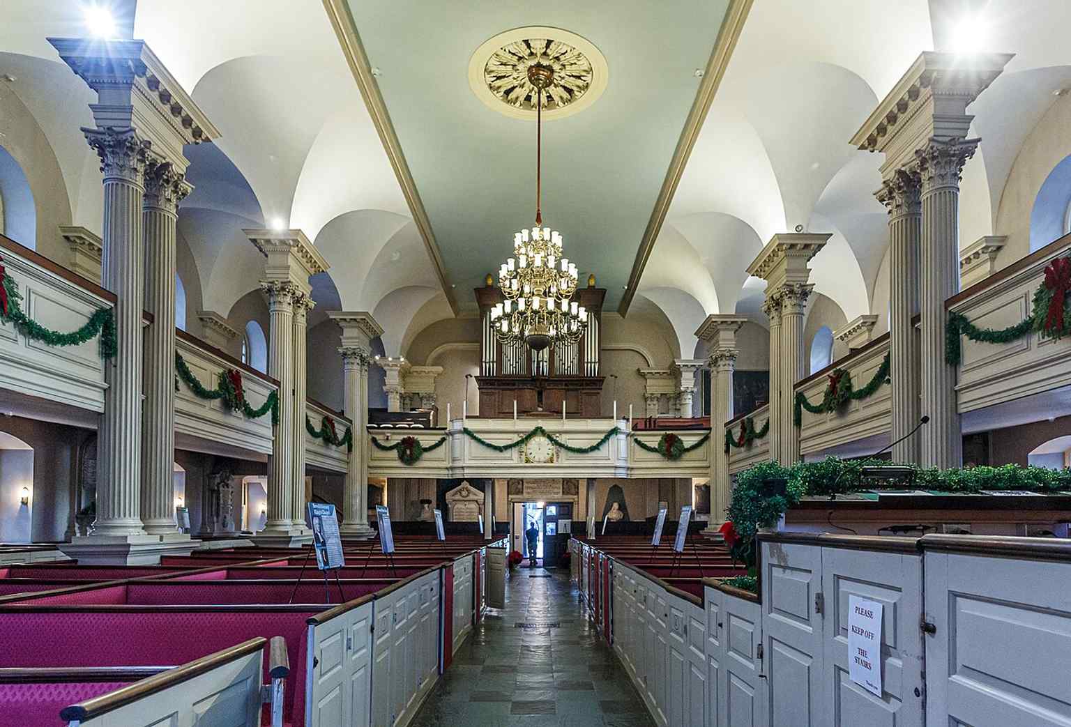 The rear of the sanctuary, showing the box-pew layout and balcony arrangement that once reflected family ownership and pew rent.