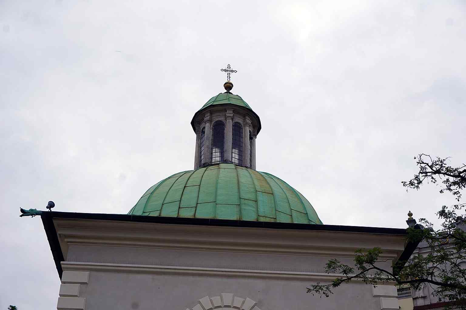 Die Kirche bei Nacht betont ihre kompakte Präsenz auf dem Platz, eine lebendige Gemeinde, die sich noch immer direkt zum geschäftigen Treiben im Zentrum Krakaus öffnet.