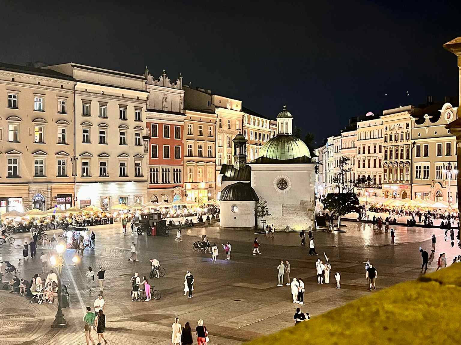 After dark, St. Adalbert glows on the edge of the Old Town Market Square, underscoring how the church remains woven into the city’s public life.