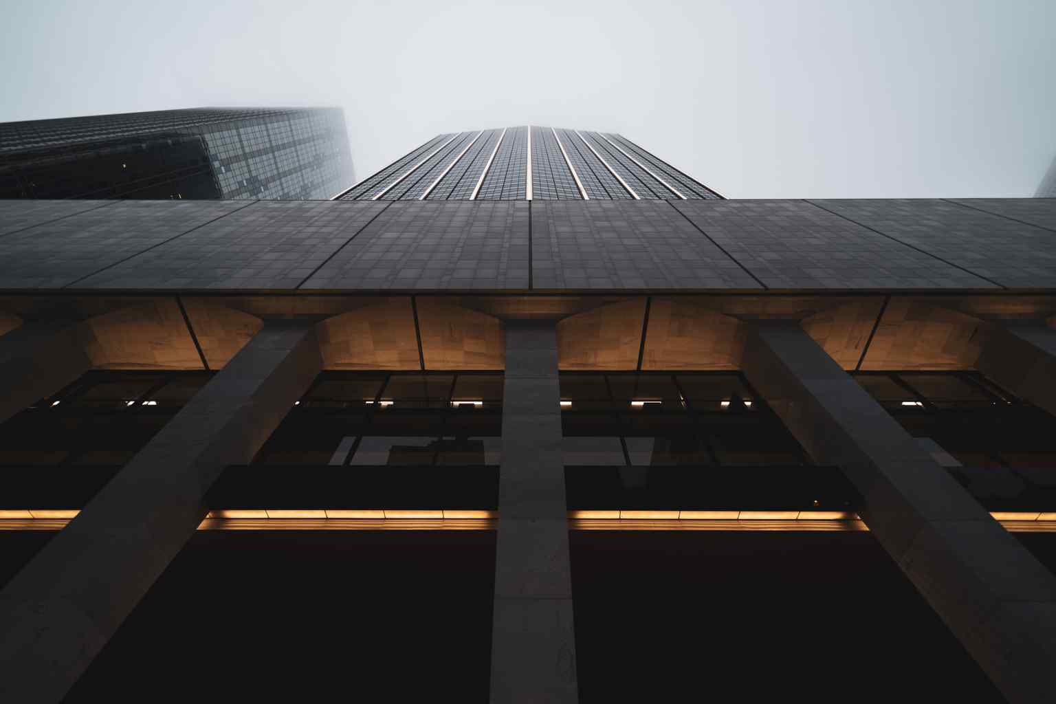Observe the building's distinct dark gray glass and white marble exterior, a contrast of materials imported from Greece for its original 1965 construction.