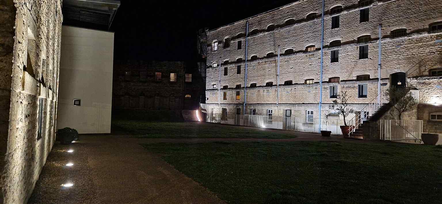 At night, the former prison blocks and House of Correction make the castle’s later penal history especially clear.