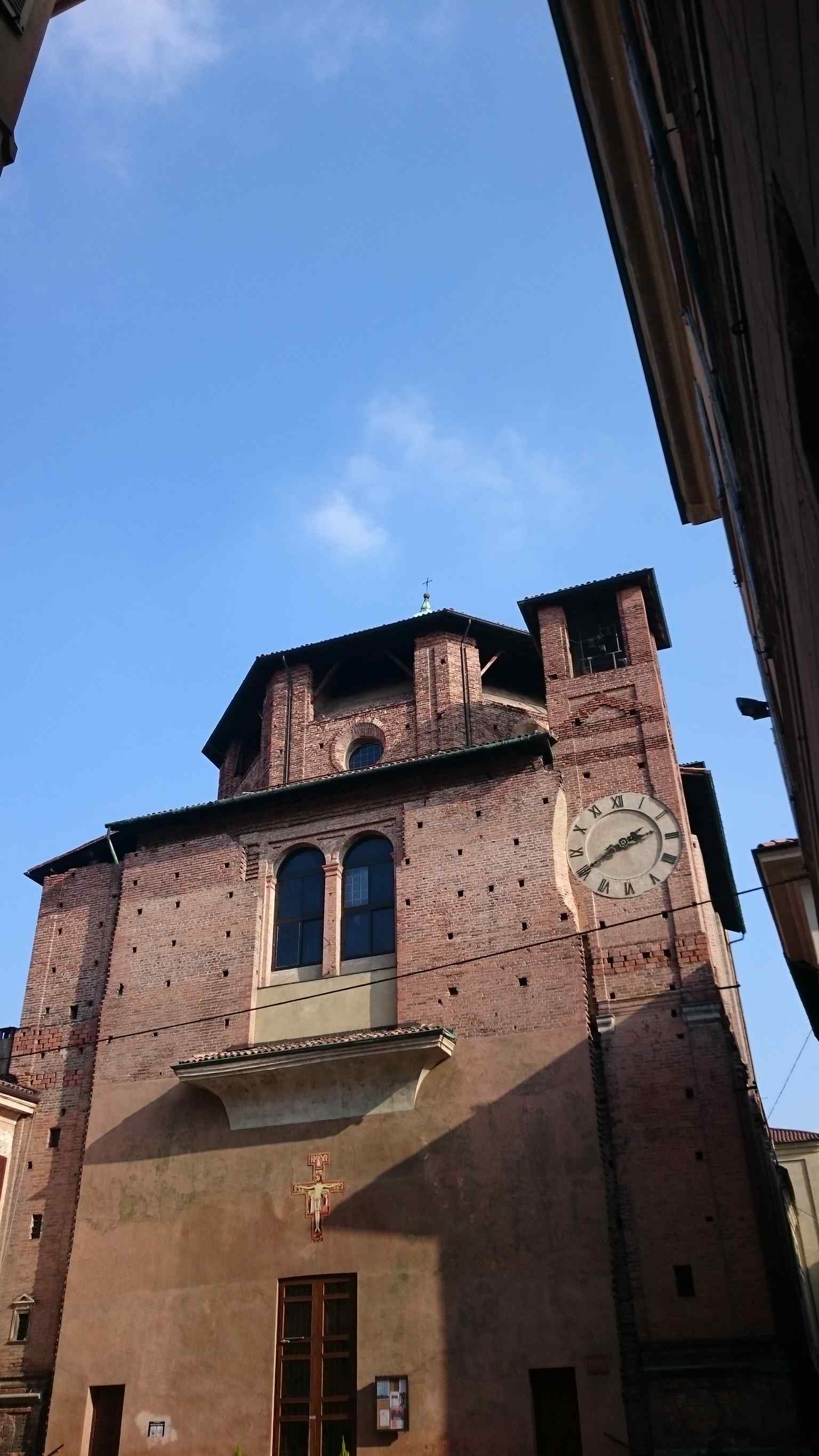 This image shows the overall ad quadratum structure and the unfinished facade of the church, reflecting its complex architectural history, once attributed to Bramante or Amadeo, now to Solari.