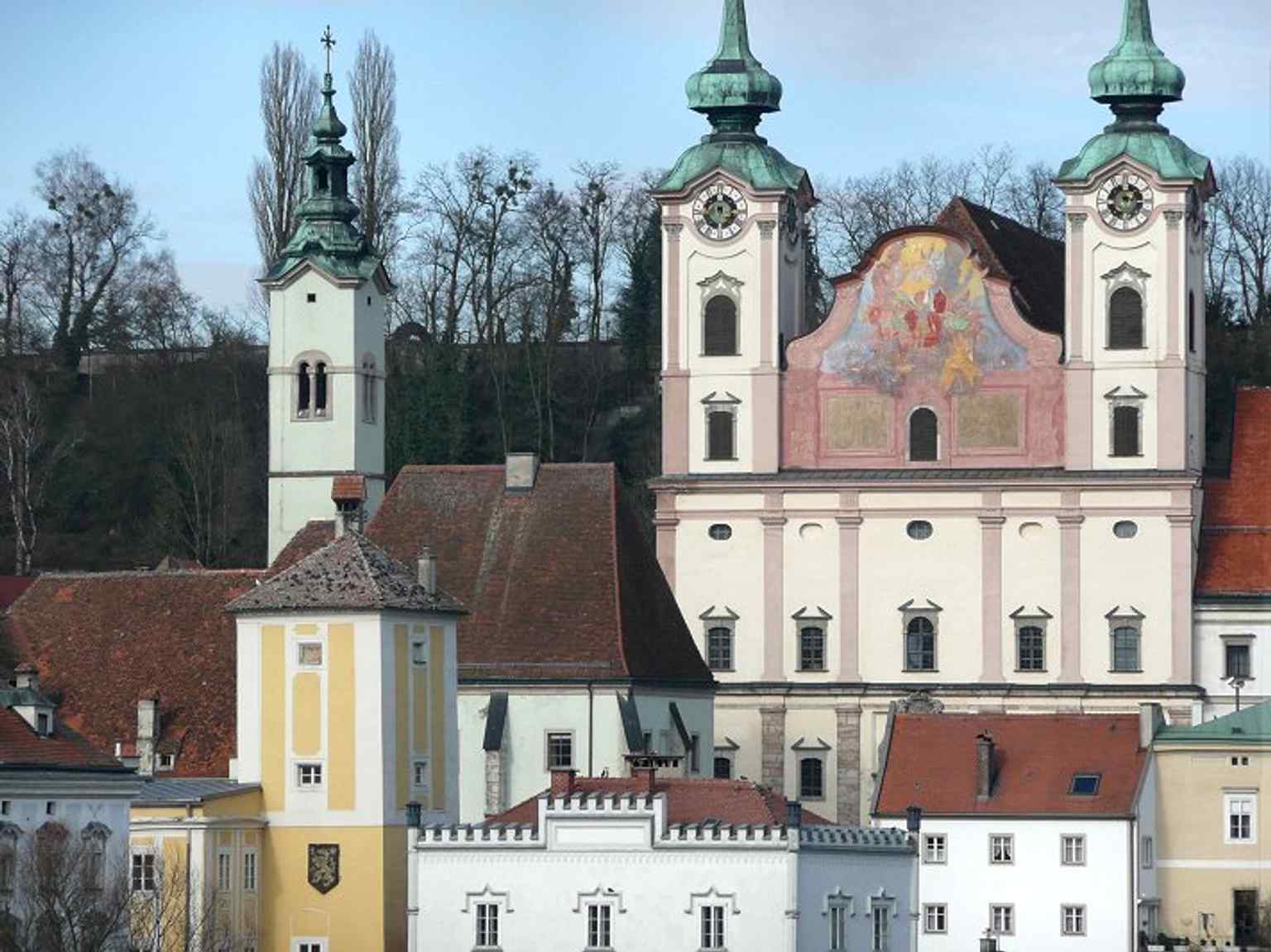 A classic full view of St. Michael rising above Steyrdorf, showing how the church dominates the river crossing and the old town skyline.