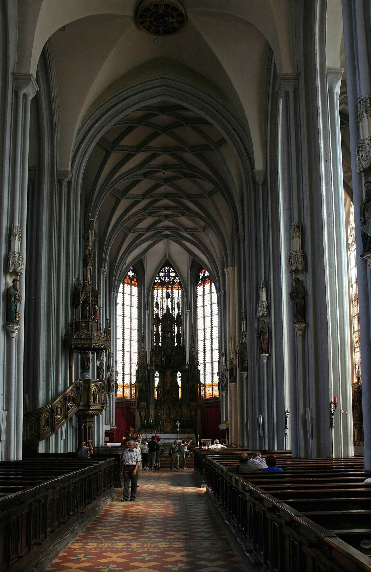 A wide nave view toward the high altar captures the church’s three-aisled Gothic hall and the neo-Gothic redesign of the 19th century.