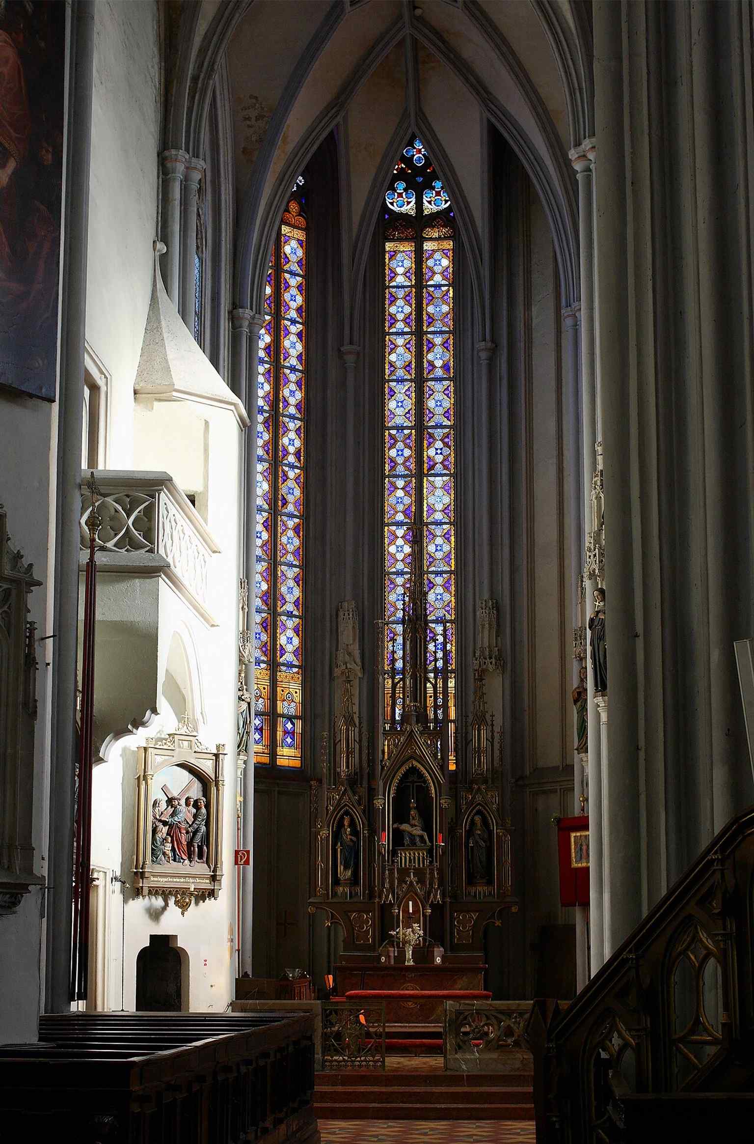 This view into the left choir aisle helps explain the church’s late-Gothic spatial structure and the long choir added in the 15th century.