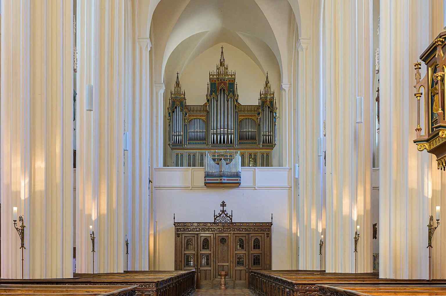 The organ loft at the main entrance connects to the church’s musical history, including Anton Bruckner’s ties to the instrument.