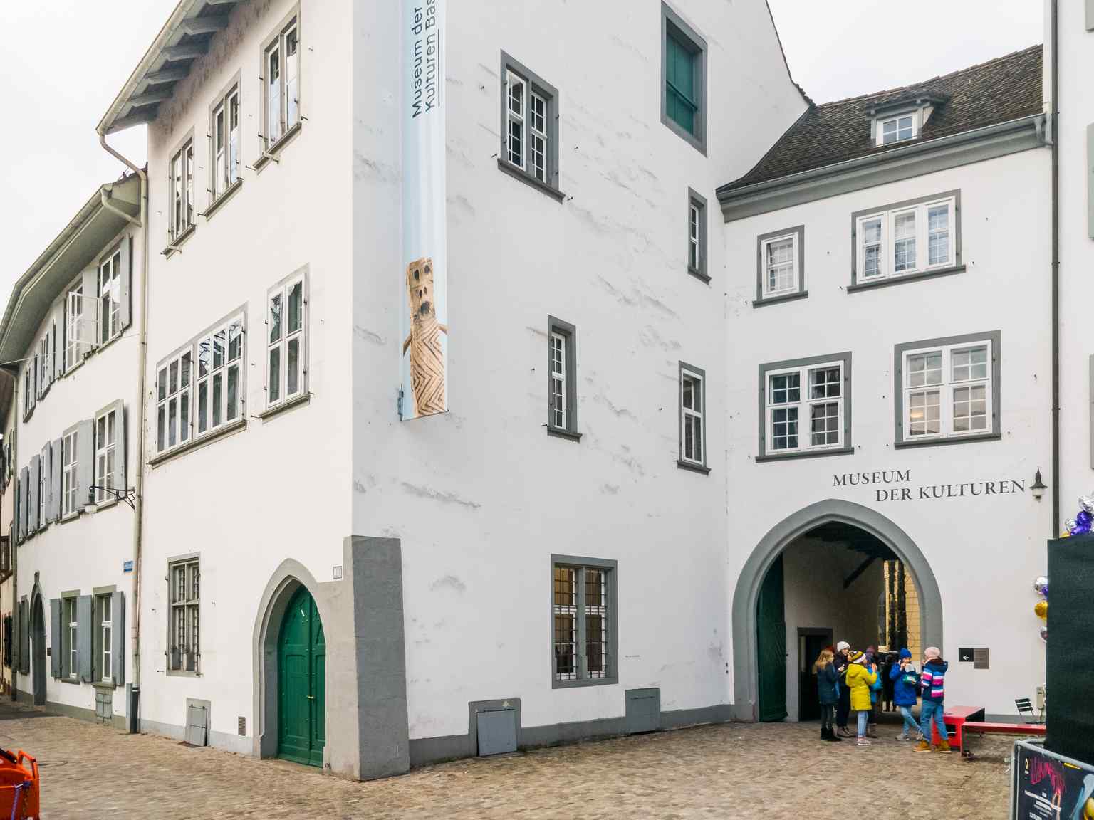 The crisp white facade and grand entryway of the Museum of Cultures Basel, viewed from Münsterplatz (2018).