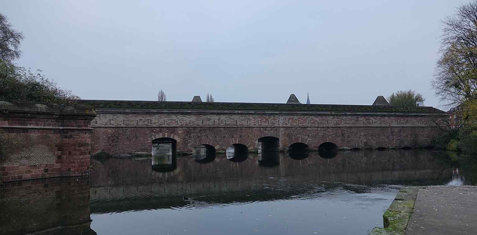A modern exterior view of the Vauban Dam, now listed as a historic monument and no longer used for military purposes.