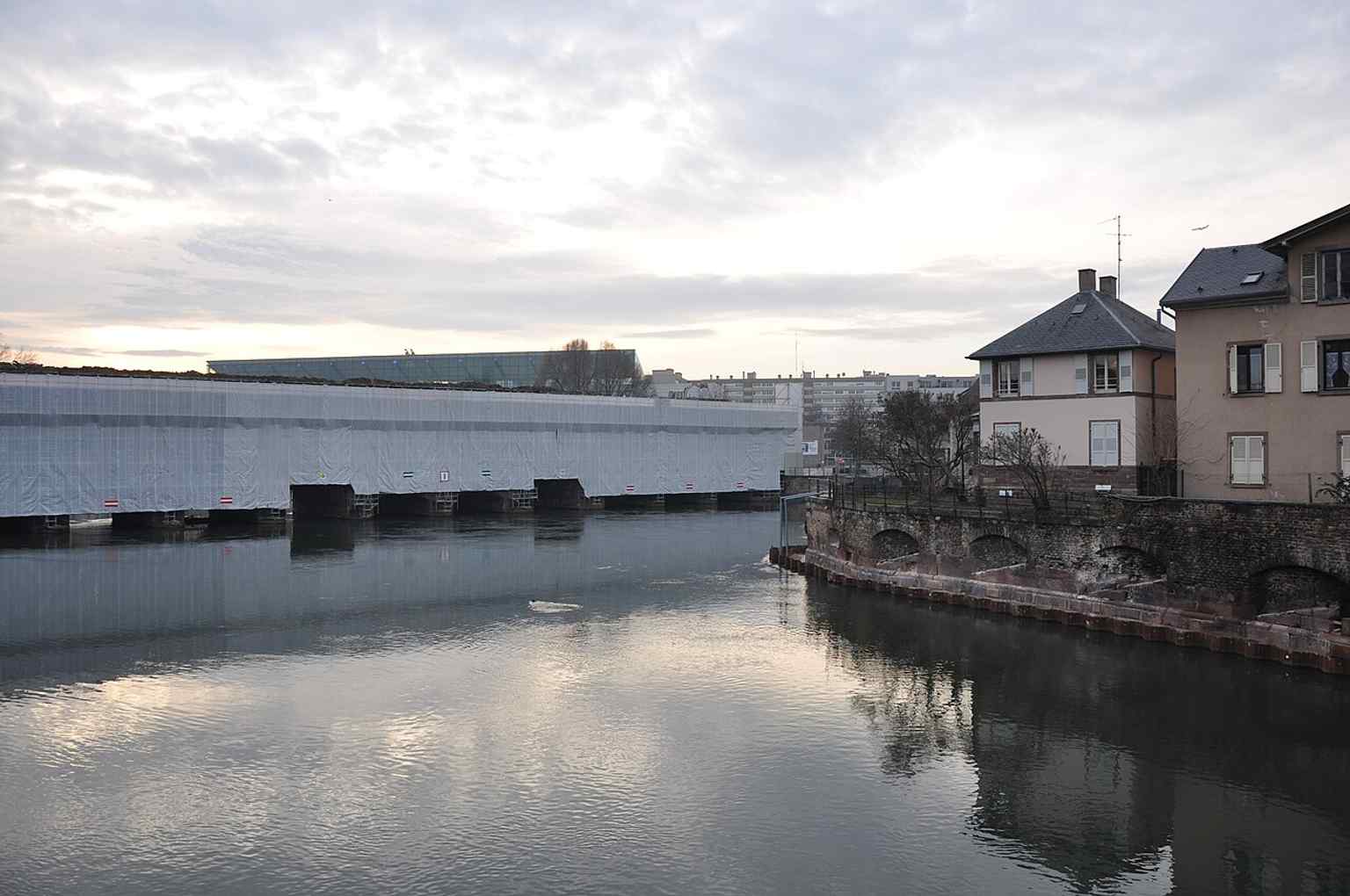 The dam from the river side, emphasizing how it spans the Ill and controls water in front of the old ramparts.
