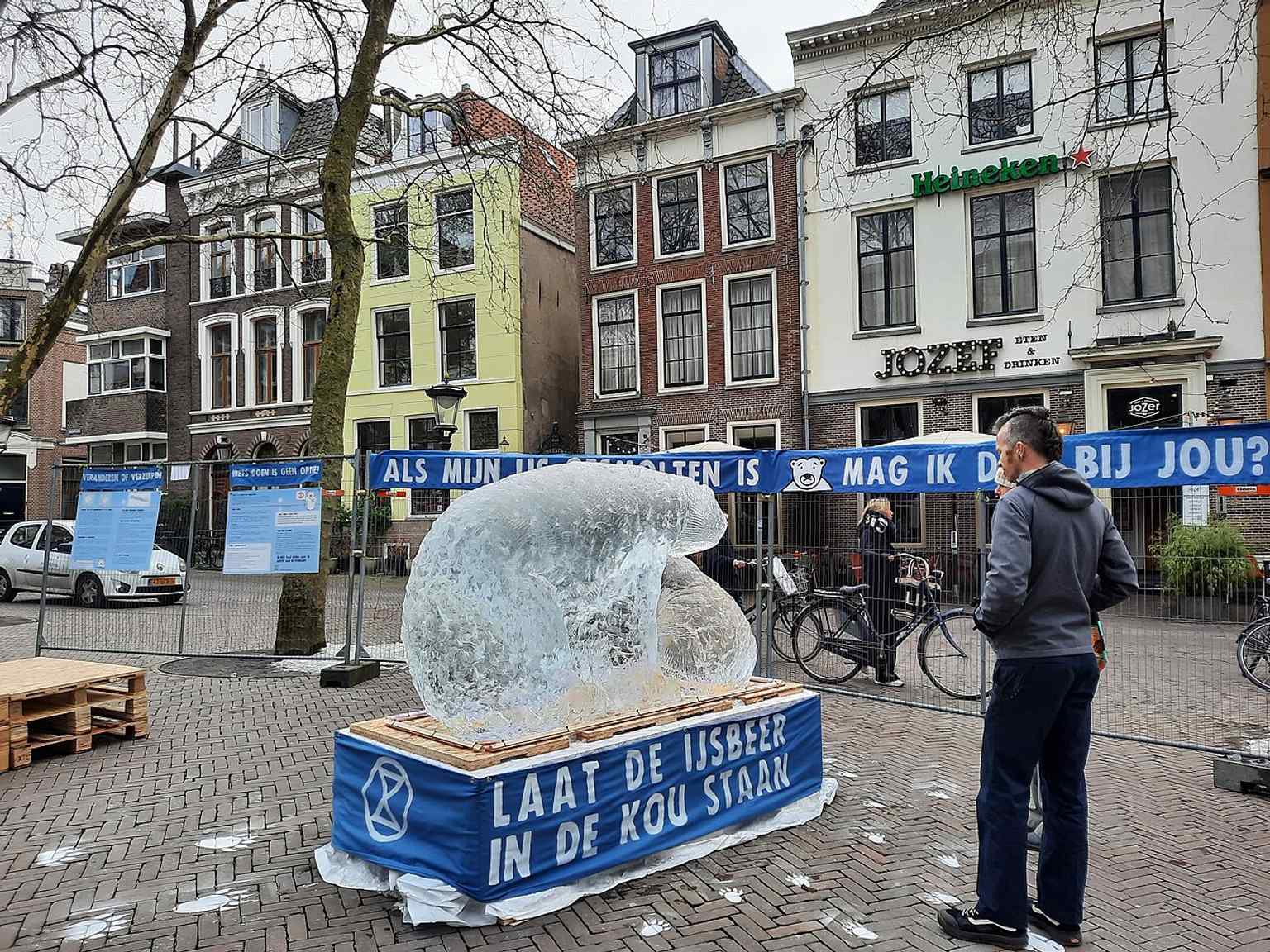 The Mariaplaats, a historic market square, hosts a protest featuring an ice sculpture of a polar bear, reflecting its continued use as a public gathering space for various events.