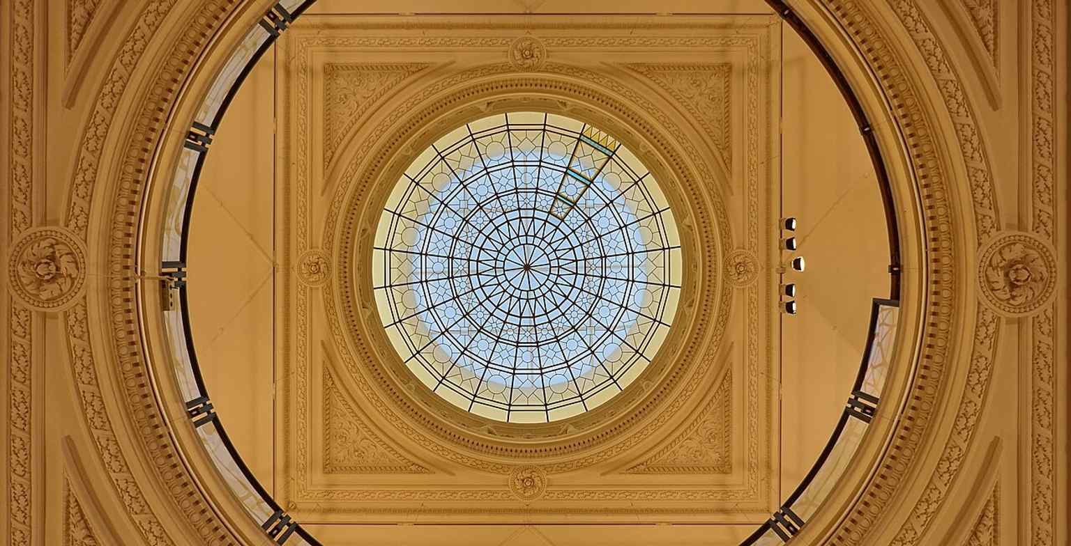 The skylight of the entrance hall, highlighting the elaborate roof structure above the historic exhibition space.