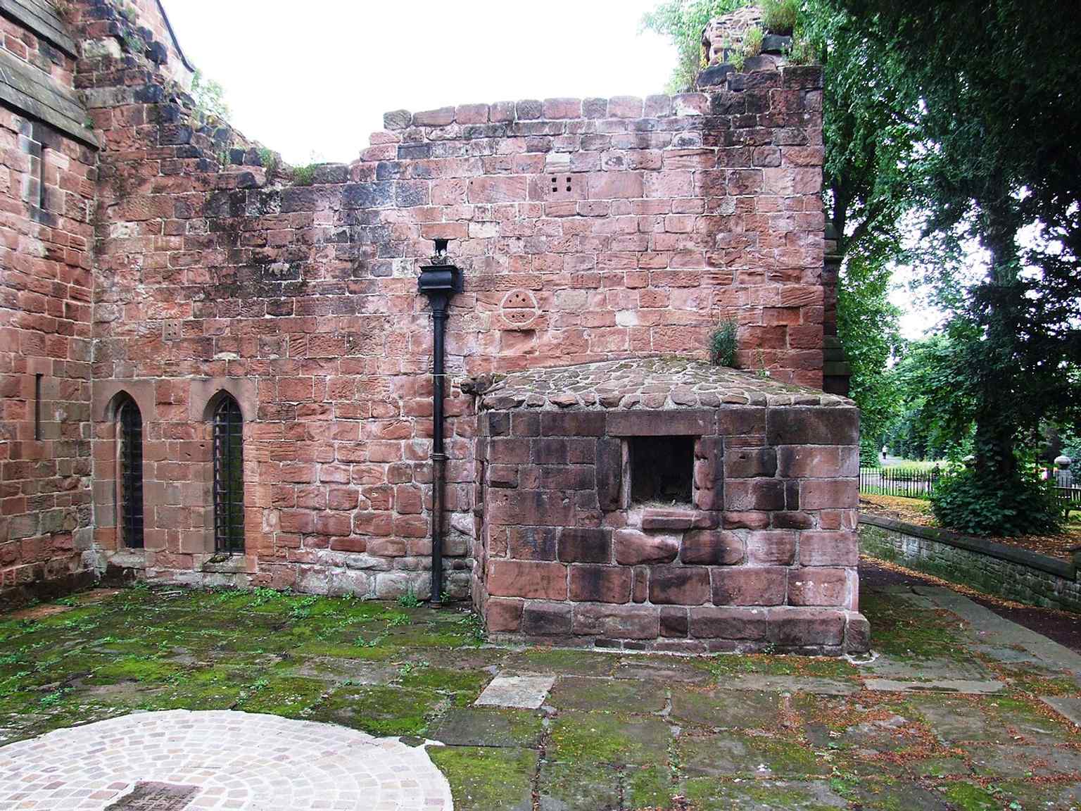 Sandstone walls and the south side of the church, part of the surviving medieval fabric that makes St John’s one of Cheshire’s best Romanesque churches.