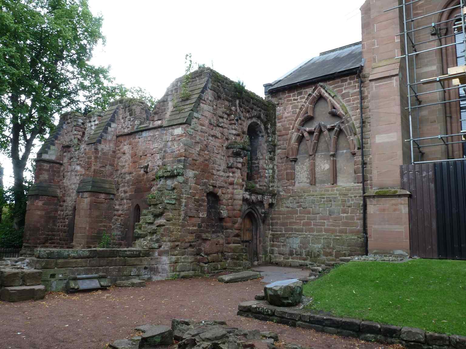 The ruined eastern remains beyond the present church, evidence of the post-Dissolution demolition that reduced St John’s from cathedral to parish church.