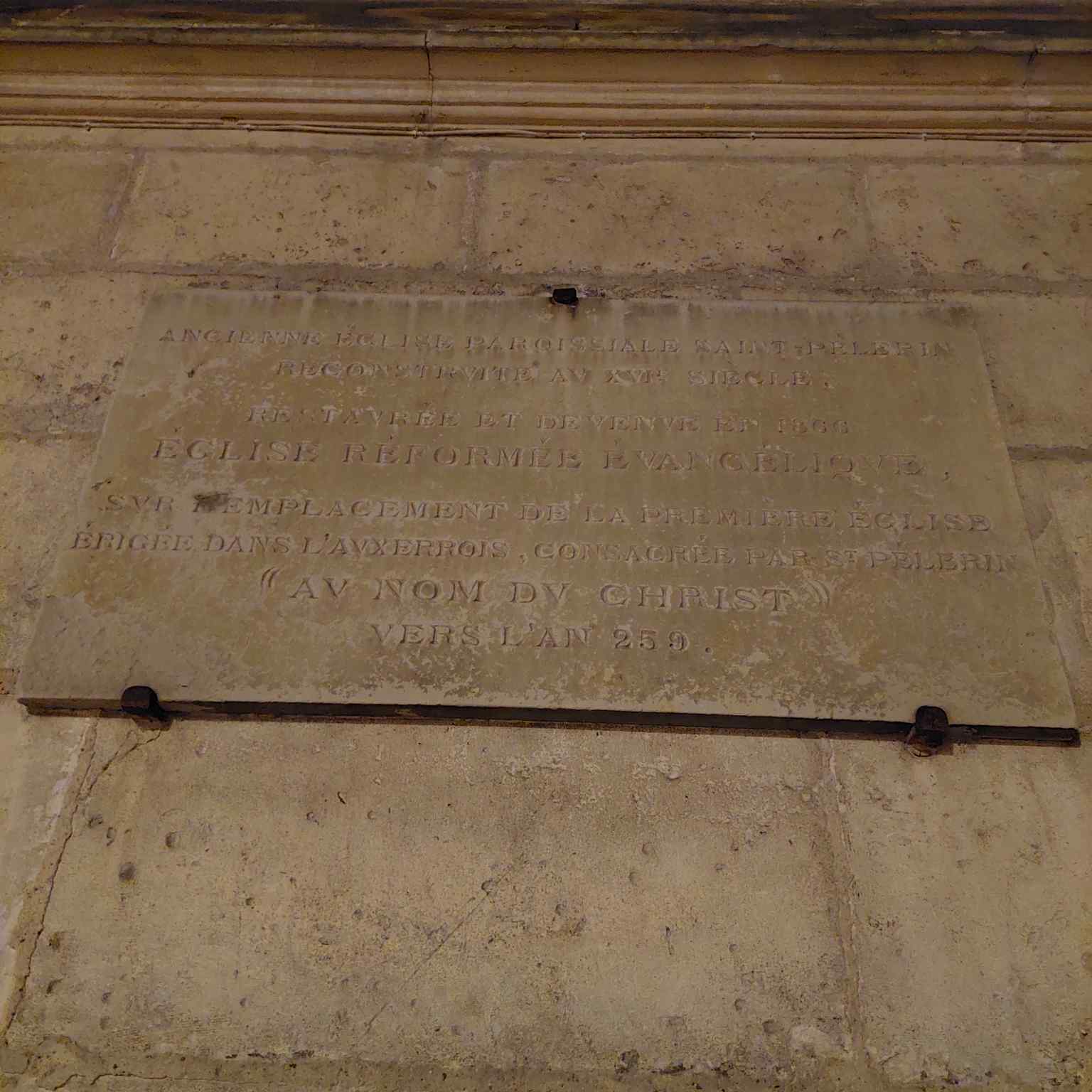A detail of the plaque on the temple's facade, located on Rue Saint-Pèlerin, chronicles its significant journey from being sold during the French Revolution in 1791 to its re-establishment as a Protestant church in 1866.