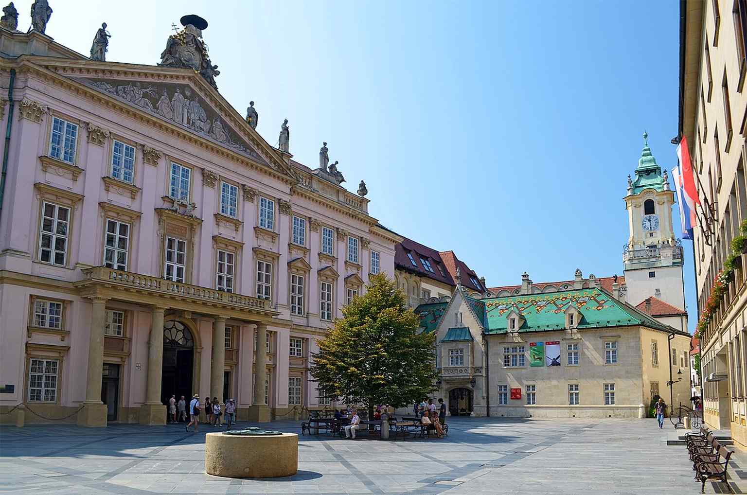 This street-level perspective shows the palace embedded in the old town fabric, echoing the text’s note about its sensitive integration into the historic core.