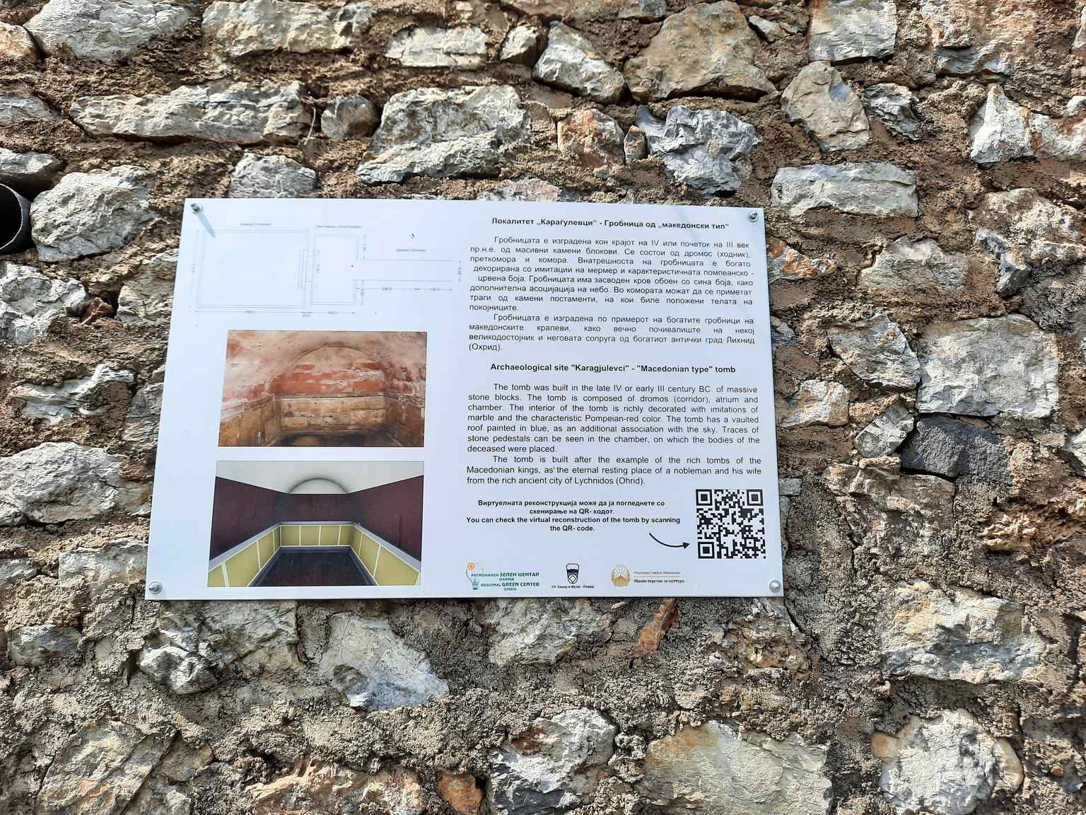 An informational plaque provides key details about the Karađulevci tomb, an ancient Macedonian burial site dating back to the 4th-3rd century BCE, now recognized as a cultural monument.