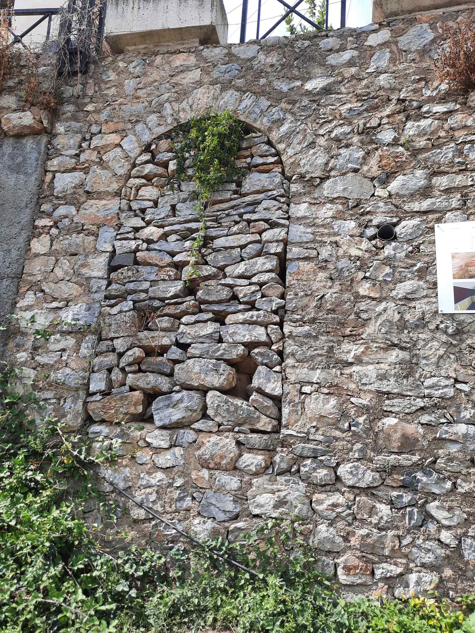 The modern-day closed entrance to the Karađulevci tomb, an archaeological site once mysteriously accessed through a narrow hole in a house basement, as described by Gustav Weigand in 1894.