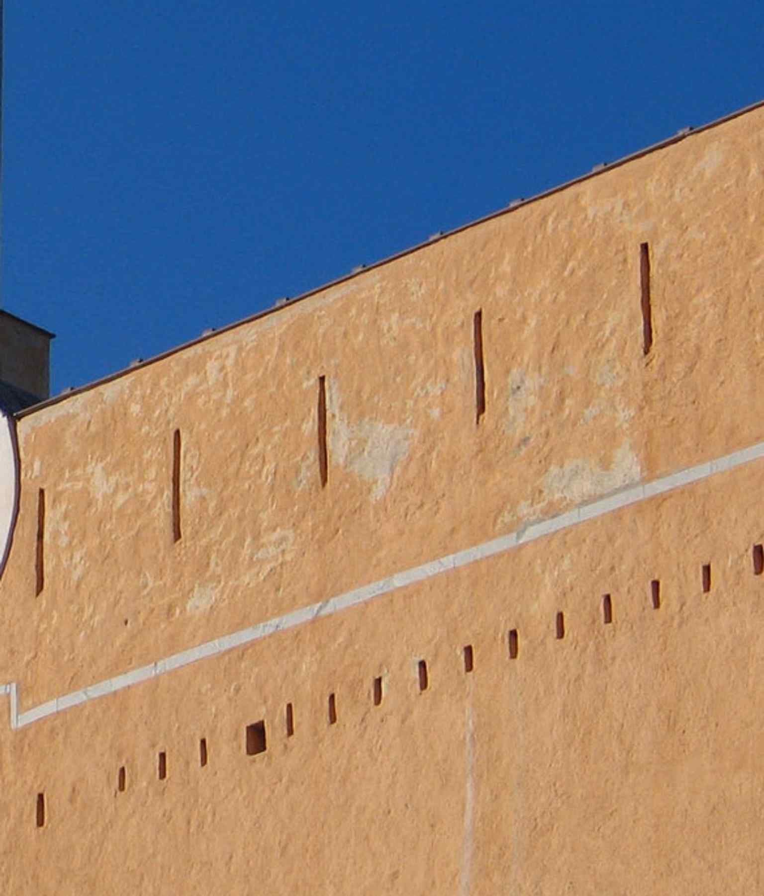 Arrow slits on the Governors' Palace facade — a reminder that this was once a Genoese fortress, not just a museum.