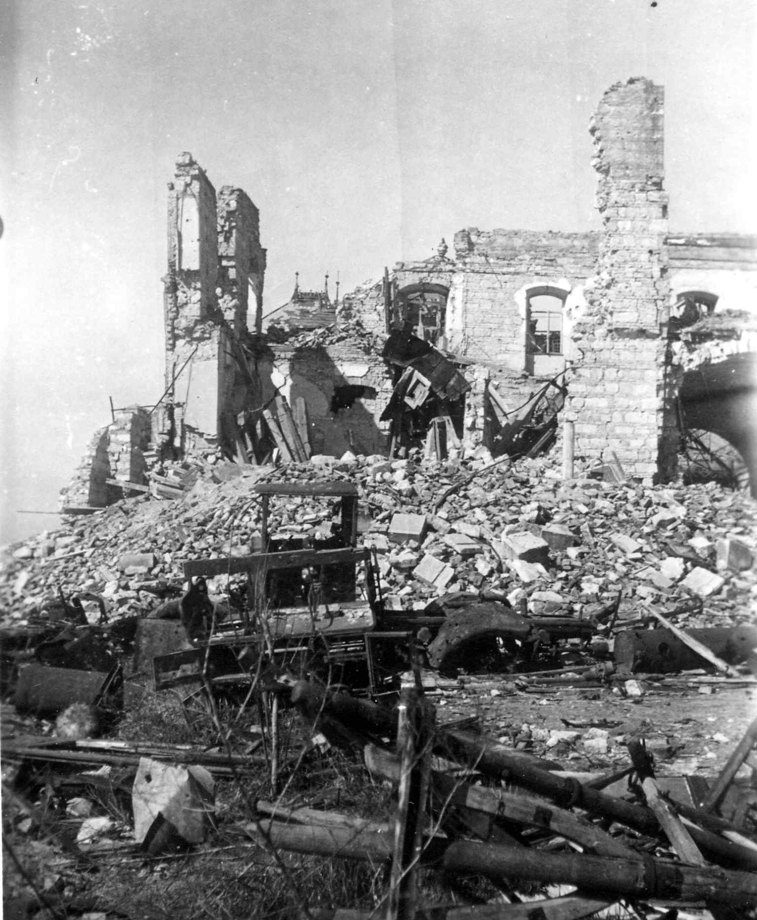 The ruins of the Royal Palace stables in 1945, with the distinctive roof ornaments of Archduke Joseph's Palace visible in the background, both severely damaged during the Siege of Buda.