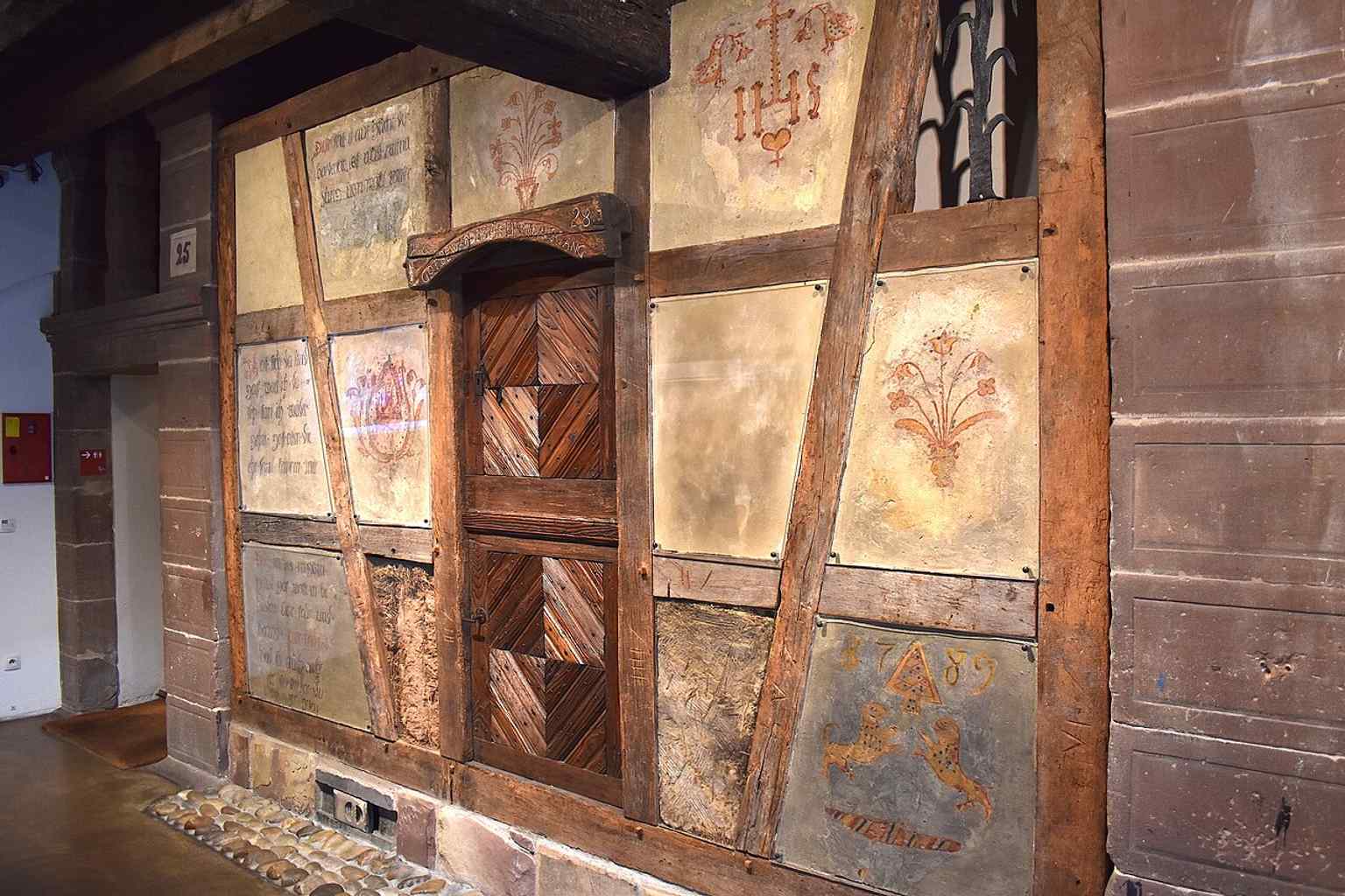 A decorated half-timber wall detail, reflecting the traditional Alsatian timber architecture shown throughout the museum.