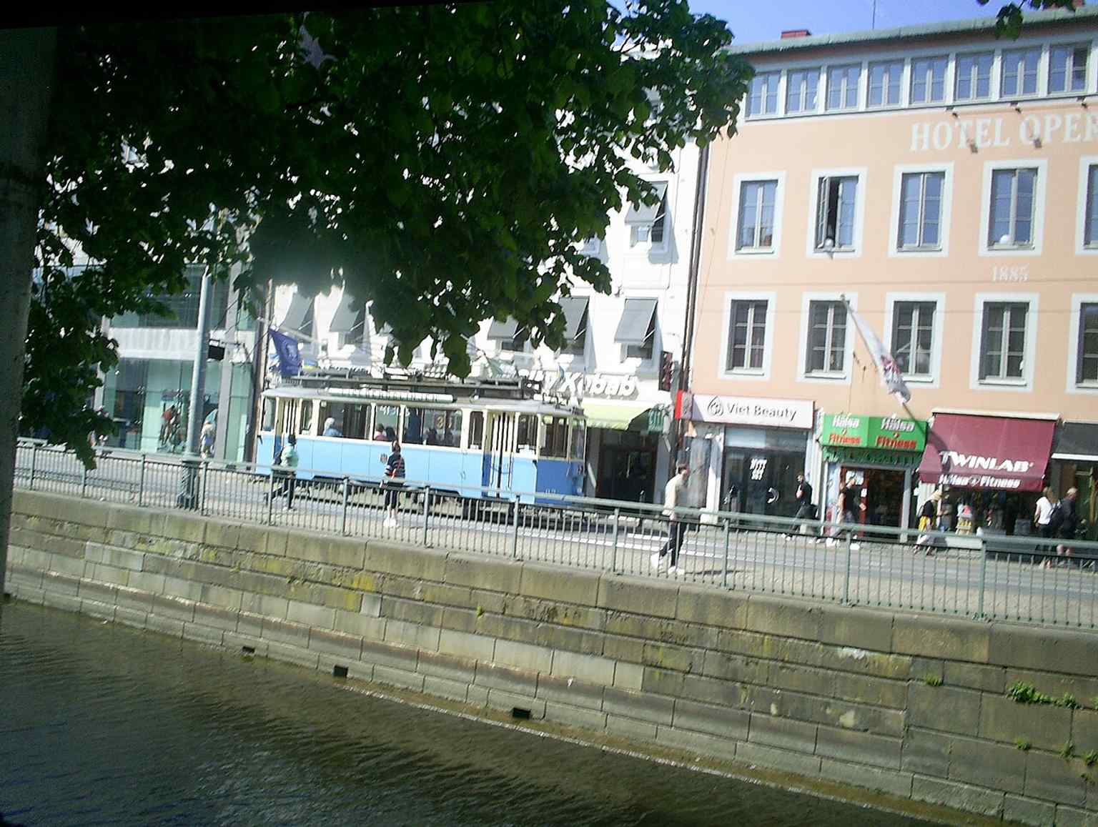 A modern tram travels along Norra Hamngatan, showcasing the street's continued role as a vibrant public thoroughfare in Göteborg.