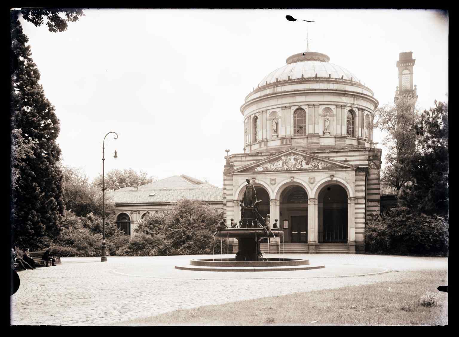 The Vierordtbad's distinctive Neorenaissance facade, featuring the Hygieia-Brunnen, a fountain created by Johannes Hirt and financed by Wilhelm Klose, installed between 1905 and 1909. It bears the inscription "Give the strong courage / The sick fresh blood".