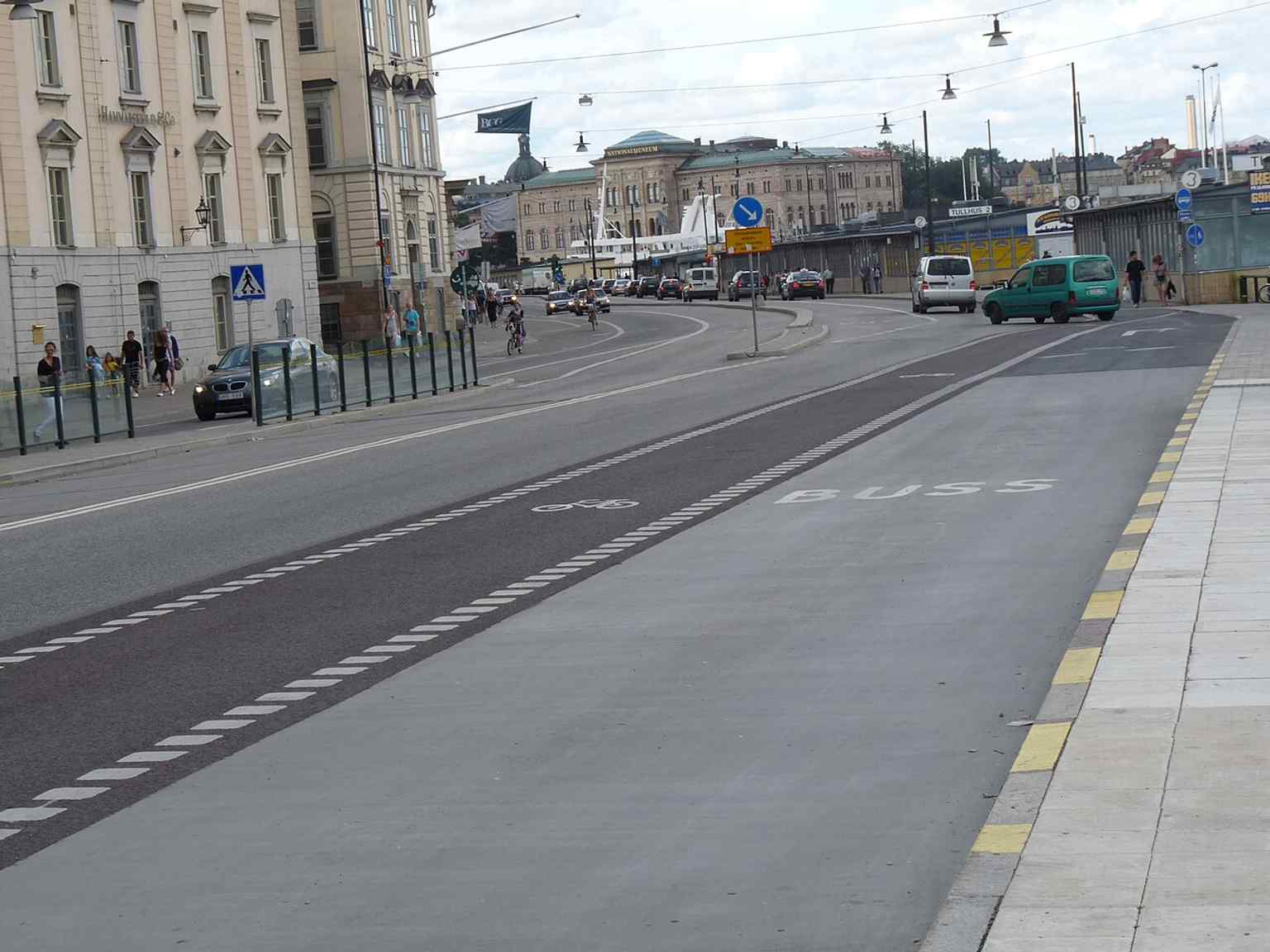 A clean street-level view of Skeppsbron, showing the broad waterfront boulevard that runs along the east side of Gamla stan.