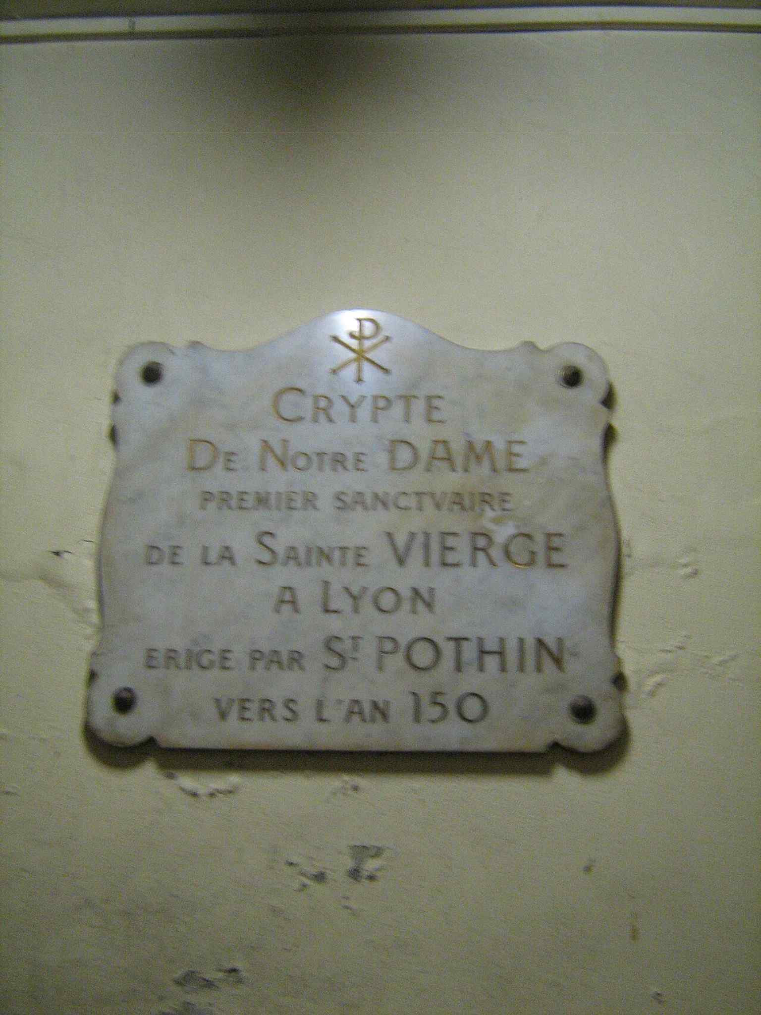 A plaque at the crypt entrance, linking the present church to the ancient burial ground and the venerable crypt below.