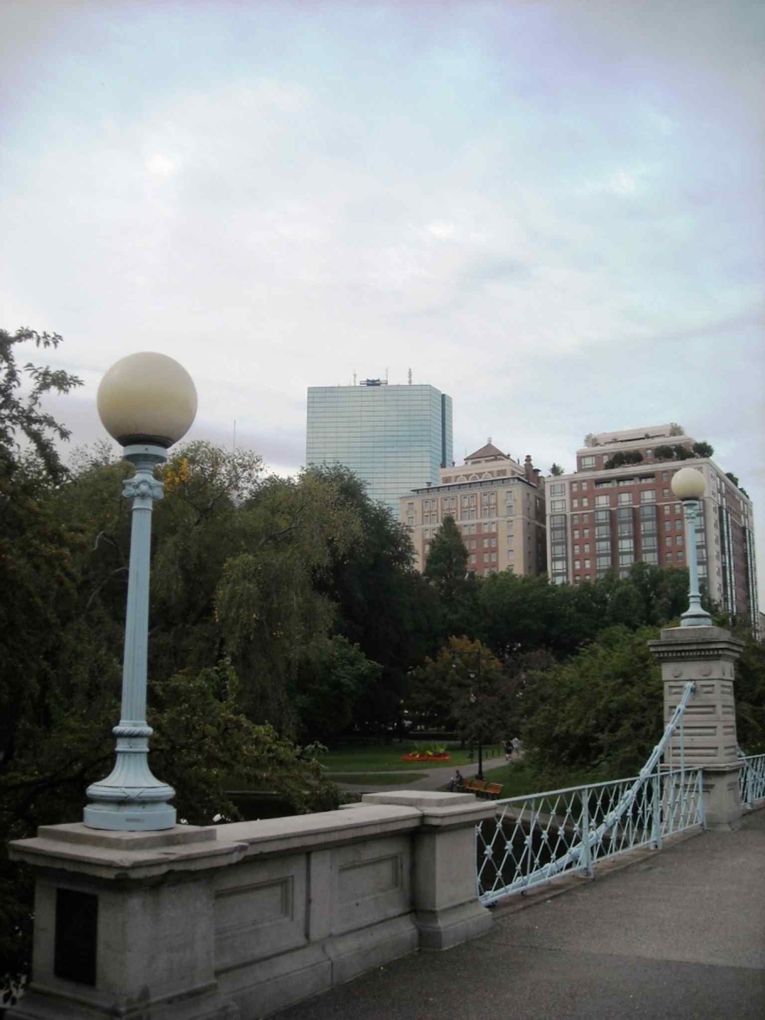 The lagoon footbridge spans the pond, echoing the garden’s signature 1867 suspension bridge design.