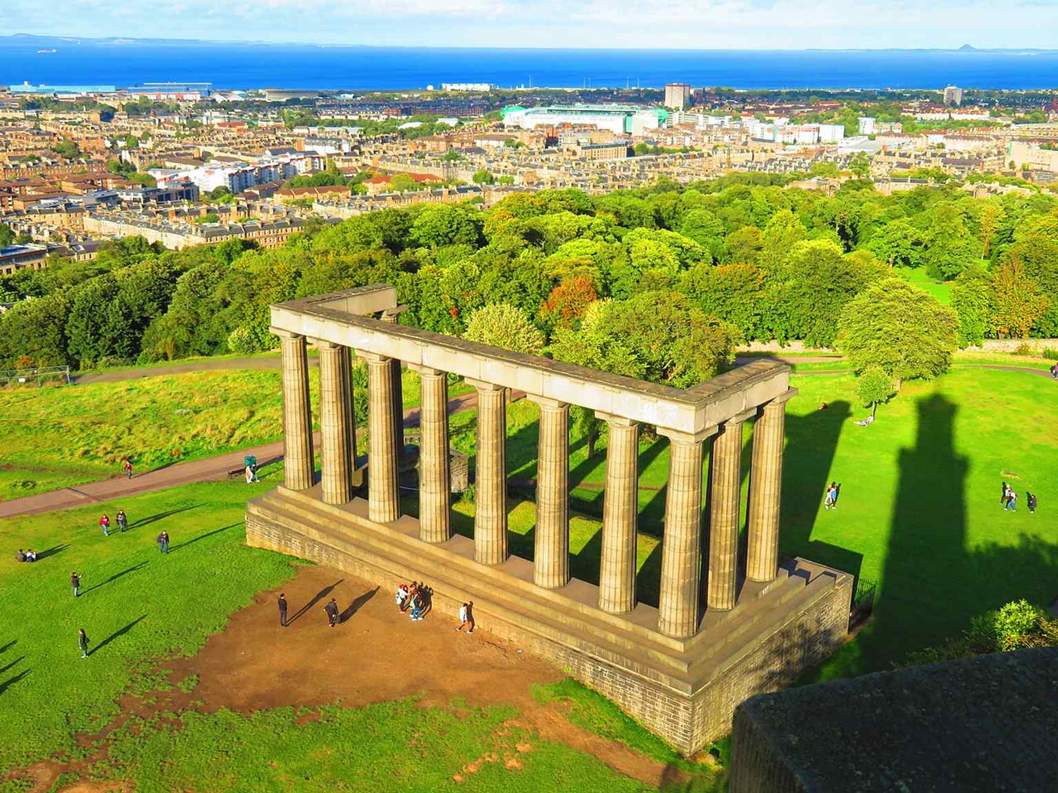 An elevated view placing the monument in its Calton Hill setting, east of Princes Street and dominating Edinburgh’s skyline.