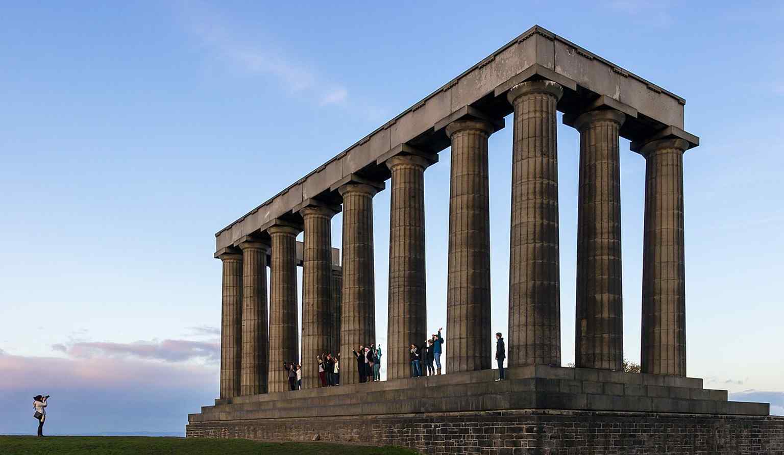 Visitors posing at the monument help convey its role as a popular viewpoint as well as a historic memorial.