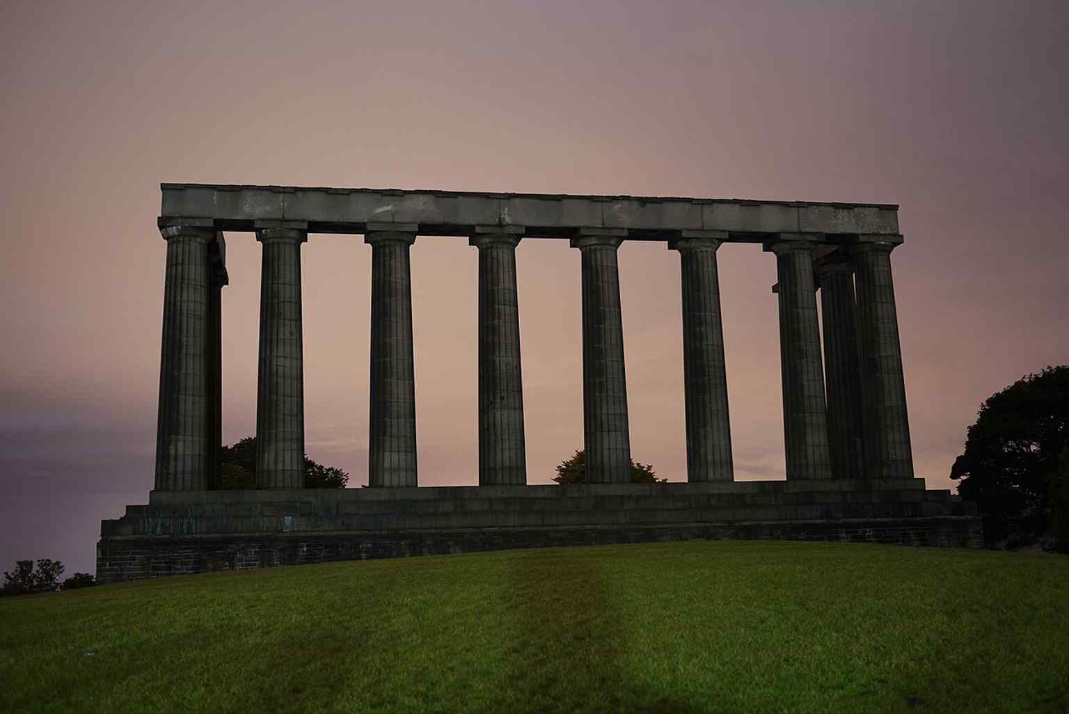 A long-exposure night shot highlighting the monument’s stark unfinished columns and its atmospheric hilltop setting.