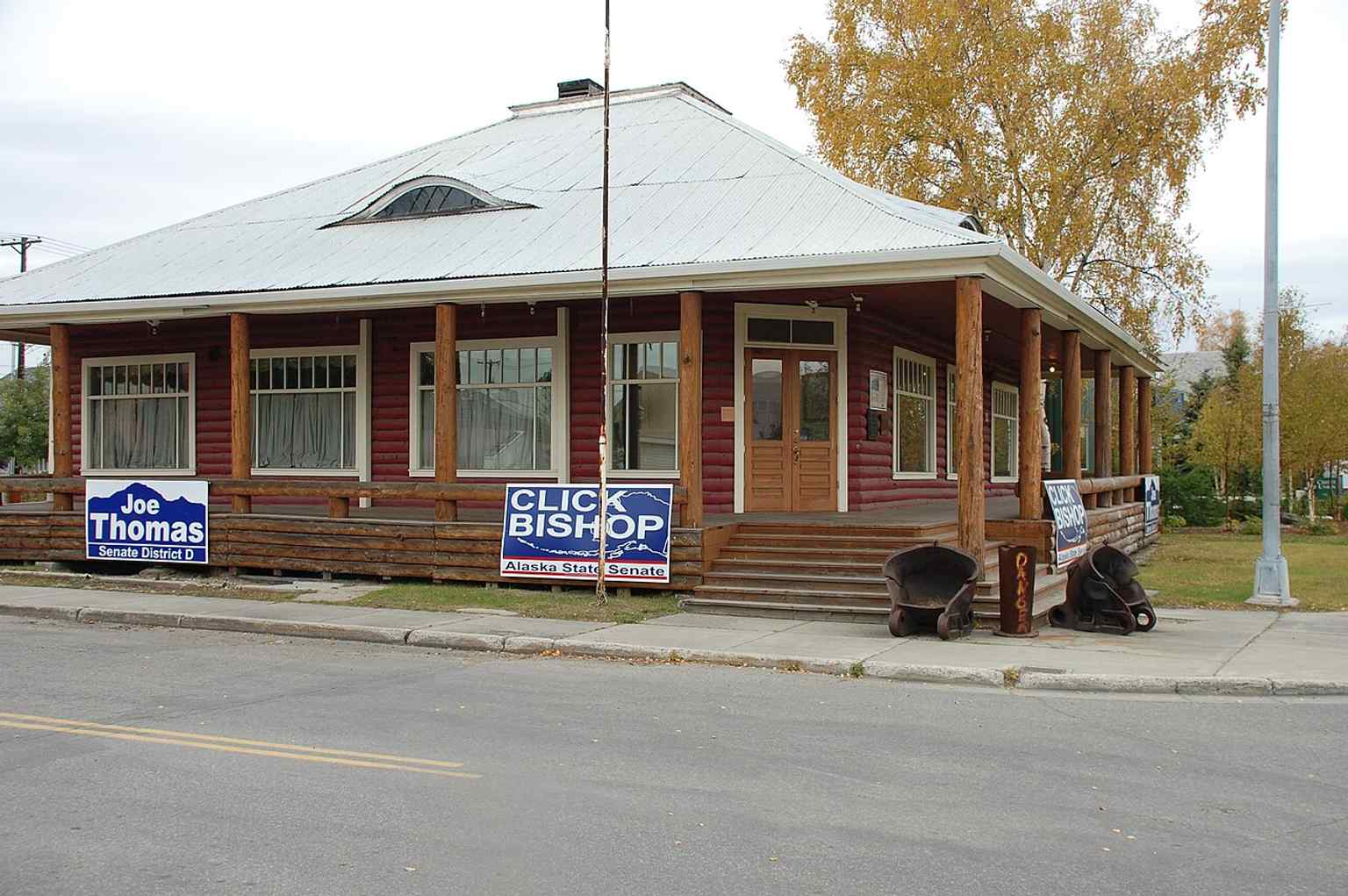 The surviving log library building in Fairbanks, still recognizable by its corner entrance and wraparound porch from the 1909 design.