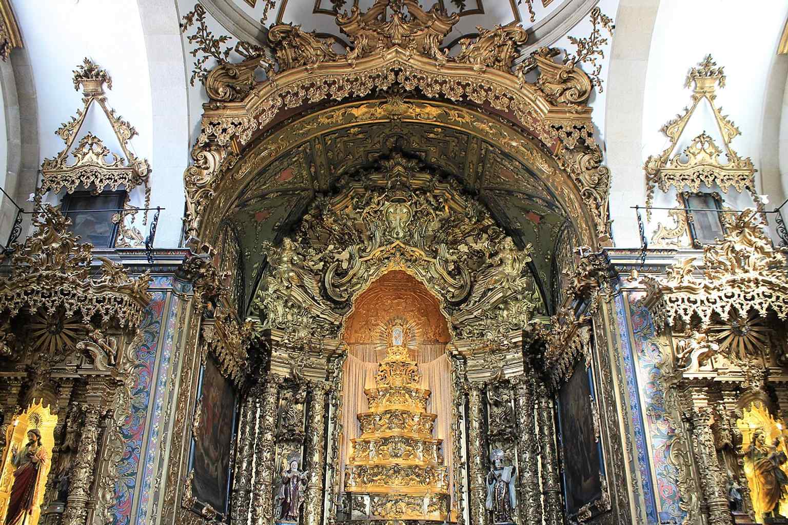 The main altar, highlighting the gilded retable associated with the Teixeira de Guimarães workshop named in the church’s history.