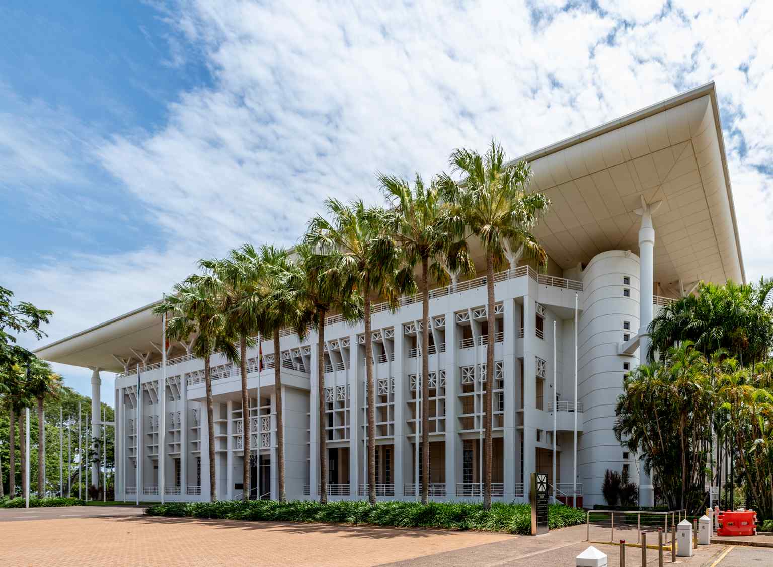 The striking 'Wedding Cake' facade of Parliament House, Darwin, a playful nickname for its stark white, layered postmodern tropical architecture.