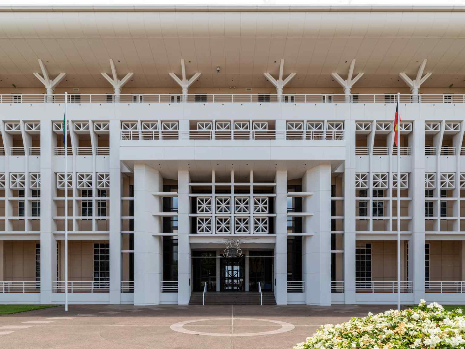 Parliament House's innovative cyclone-resistant design, featuring a parasol roof and facade that diffuses 80% of direct sunlight, built after previous buildings were damaged by Cyclone Tracy.