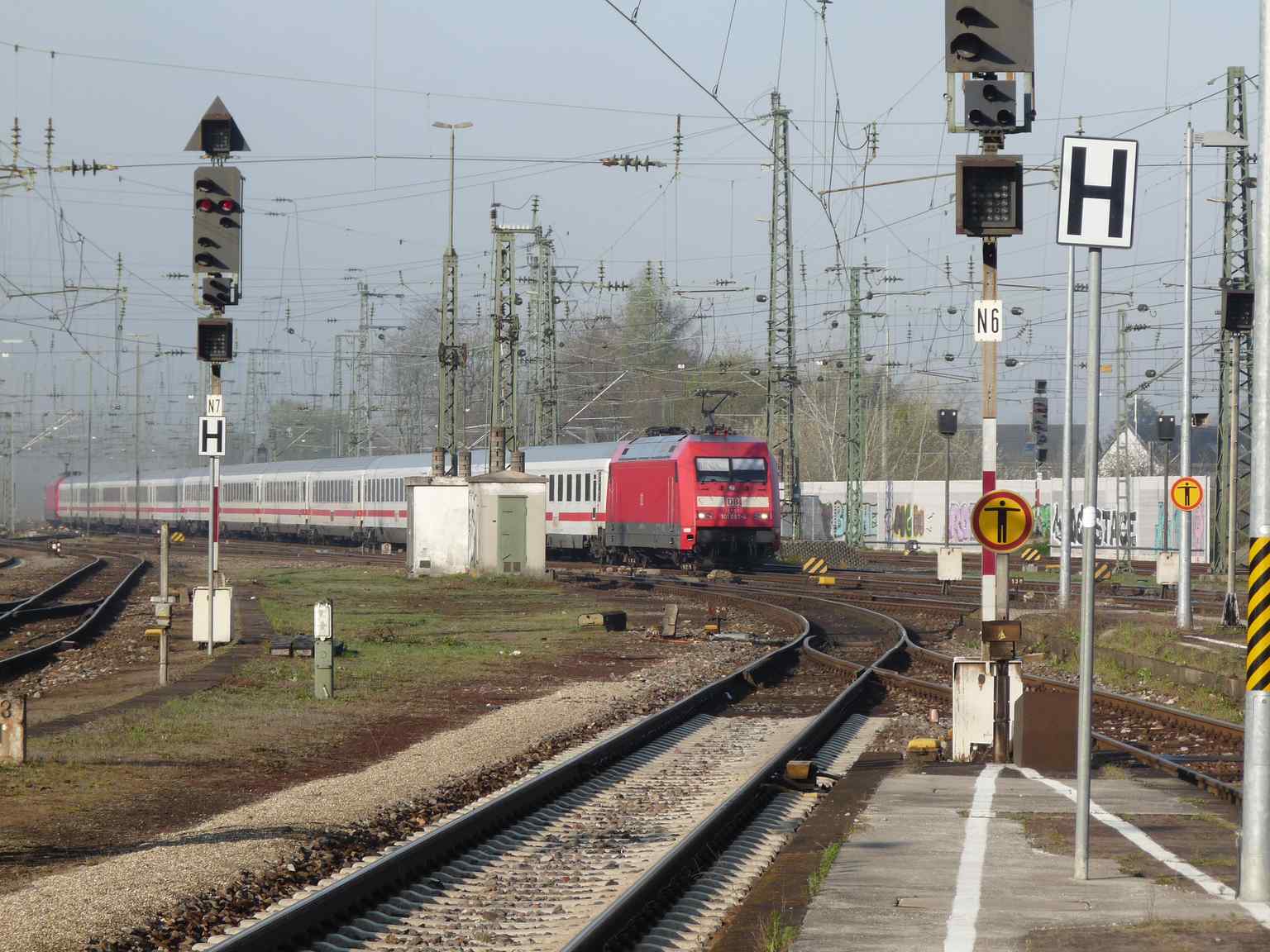 An Intercity train arriving at Karlsruhe Central Station through morning mist, highlighting its role as a key hub for national rail connections and its continuous operation as a busy railway intersection.
