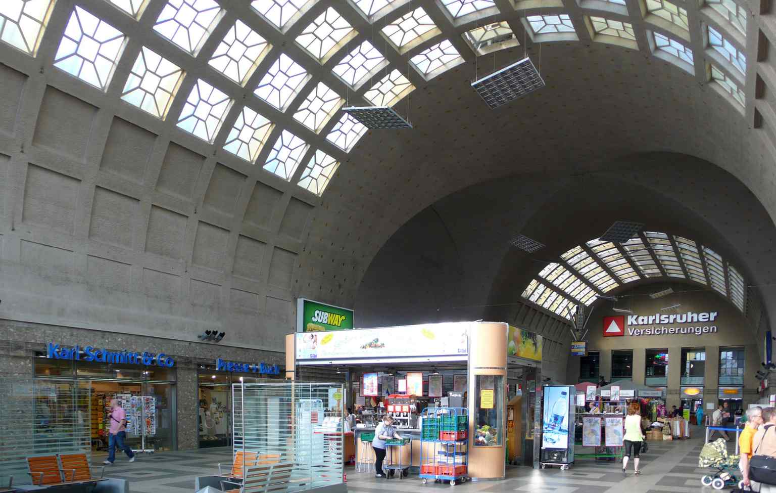 Inside the main reception hall or a covered platform, part of the five-nave steel train shed that covers the island platforms, similar to the Breslau Central Station.